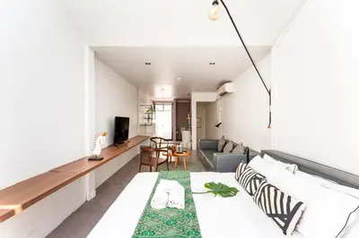 a bedroom with a bed and a living room at MIQ_5br/Silom Bts,Mrt/Wifi 1000MB/Jacuzzi/16pax in Bangkok