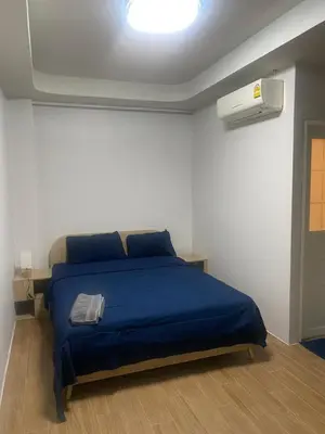 a bedroom with a bed with a blue blanket at N place Huai Khwang in Bangkok