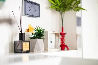 a room with plants and a tv on a shelf at Belivin99 Residence Chinatown in Bangkok