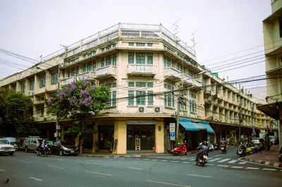 a large building on a city street with people riding motorcycles at Belivin99 Residence Chinatown in Bangkok