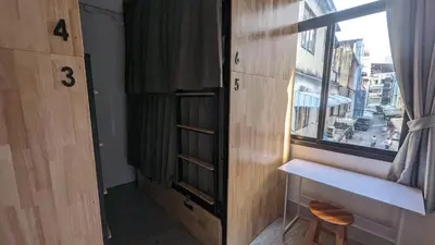 a room with a window and a table and a shelf at Urban Jungle Social in Bangkok
