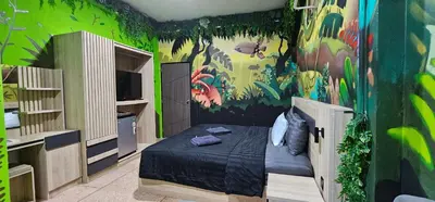 a bedroom with a bed and a green wall at Urban Jungle Social in Bangkok