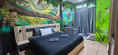 a bedroom with a bed and a chair in it at Urban Jungle Social in Bangkok