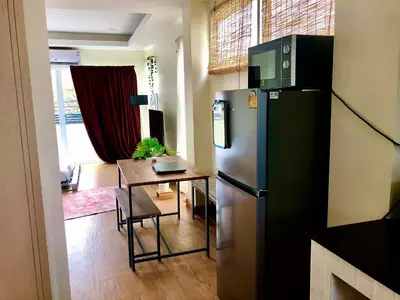 a kitchen with a stainless steel refrigerator and a table at The Apartium - Modern Apartment Rentals in Bangkok