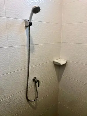 a shower with a shower head in a bathroom at The Apartium - Modern Apartment Rentals in Bangkok