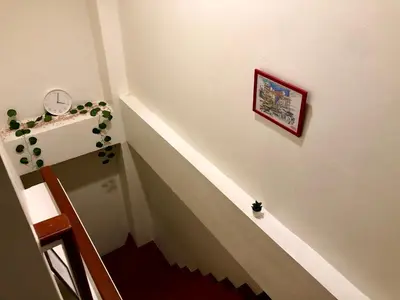 a hallway with a stairway with a clock on the wall at The Apartium - Modern Apartment Rentals in Bangkok