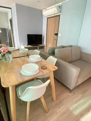 a living room with a table and a couch at Ideo O2 BTS Bangna in Bangkok