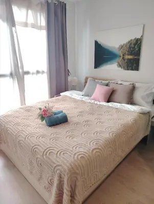 a bedroom with a large bed with a large window at Ideo O2 BTS Bangna in Bangkok