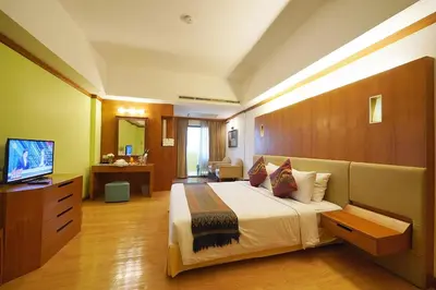 a hotel room with a bed and a television at Riverside Bangkok Hotel in Bangkok
