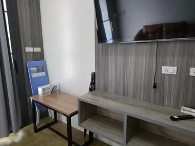 a room with a wooden cabinet with a table and a mirror at Victory Place in Bangkok