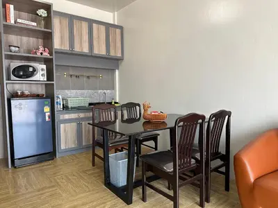 a kitchen with a table and chairs and a refrigerator at Victory Place in Bangkok
