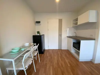 a kitchen with a table and chairs in a room at Garden Oasis Apartment: Condo Near Bangkok River in Ban Sai Ma
