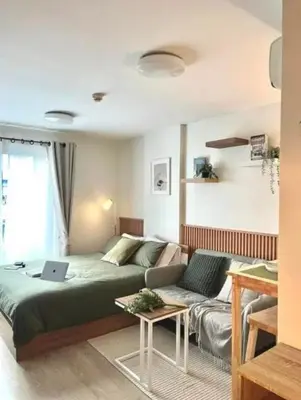 a living room with a bed and a couch at Elio Sukhumvit 64: Chic Space in Bangkok