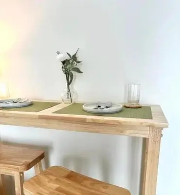 a table with two plates and a vase with flowers on it at Elio Sukhumvit 64: Chic Space in Bangkok