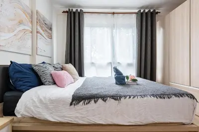a bedroom with a large bed with a window at Elio Del Ray BTS Punnawithi in Bangkok