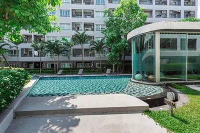 a swimming pool in front of a building at Elio Sukhumvit 64 in Bangkok