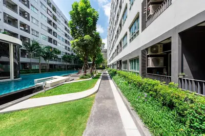 an alley between two buildings with a swimming pool at Elio Sukhumvit 64 in Bangkok
