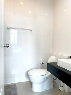 a white bathroom with a toilet and a sink at Appartment ASTRO Condo 30 days minimum in Pak Kret