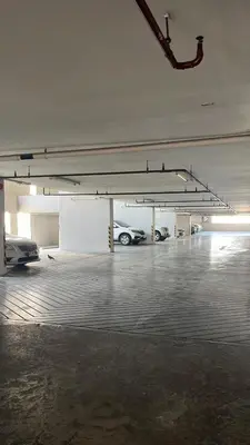 a parking garage with two cars parked in it at Appartment ASTRO Condo 30 days minimum in Pak Kret