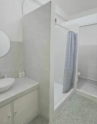 a bathroom with a shower and a sink at W District Guesthouse in Bangkok