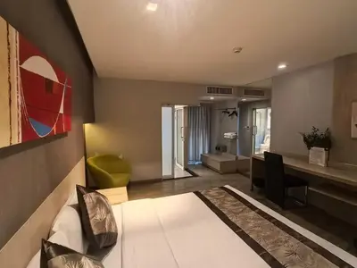 a living room with a bed and a desk with a chair at Palette Hi Hotel Bangkok in Makkasan