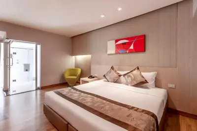 a hotel room with a large bed and a chair at Palette Hi Hotel Bangkok in Makkasan