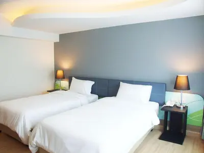 two beds sitting next to each other in a room at Grand Tower Inn Sathorn Hotel in Bangkok