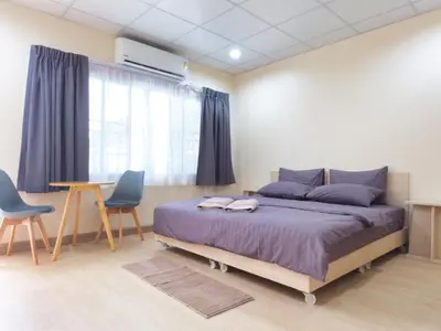 a bedroom with a bed and two chairs and a table at Studio 36 in Bangkok