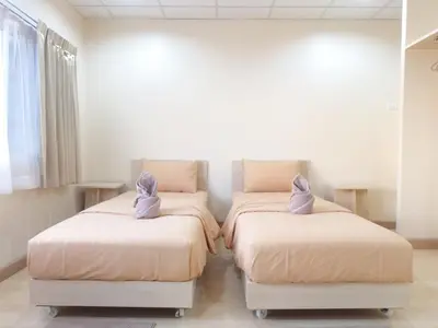 two beds in a room with pink towels on them at Studio 36 in Bangkok
