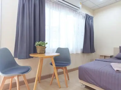 a bedroom with a table and two chairs and a bed at Studio 36 in Bangkok