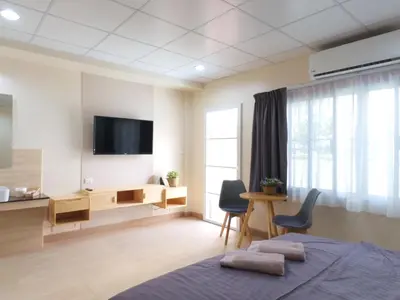 a bedroom with a tv and a bed and a desk at Studio 36 in Bangkok