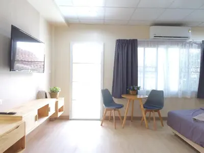a bedroom with a bed and a table and chairs at Studio 36 in Bangkok