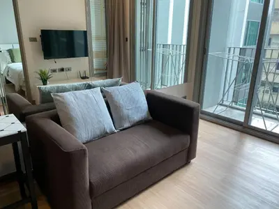 a brown couch in a living room with a tv at Ceil by Sansiri BTS Ekamai Shuttle to BTS Ekamai , Gateway mall , Major Cineplex mid city. Great place to explore bangkok in Bangkok