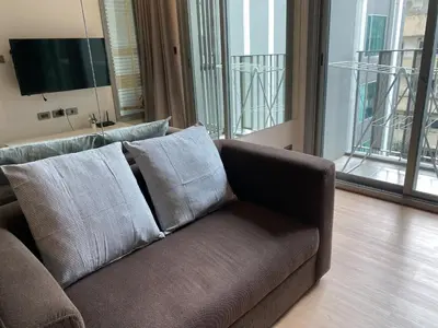 a brown couch with pillows in a living room at Ceil by Sansiri BTS Ekamai Shuttle to BTS Ekamai , Gateway mall , Major Cineplex mid city. Great place to explore bangkok in Bangkok
