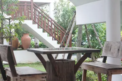 a table and two chairs and a staircase at Thaihome Resort in Ban Bang Muang