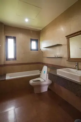 a bathroom with a toilet and a tub and a sink at Thaihome Resort in Ban Bang Muang