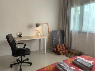 a bedroom with a desk and a chair next to a bed at COSY 4th floor with rooftop in Bangkok