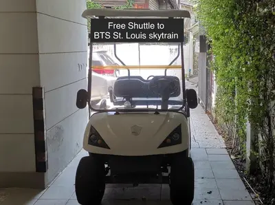 a golf cart parked on a sidewalk with a sign on it at Sathon 15 apartment close to BTS Skytrain St Louis & Surasak in Bangkok