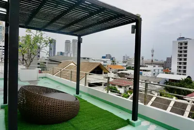 a balcony with a bench and a view of the city at Sathon 15 apartment close to BTS Skytrain St Louis & Surasak in Bangkok