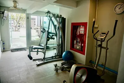 a gym with several exercise bikes and a mirror at Sathon 15 apartment close to BTS Skytrain St Louis & Surasak in Bangkok