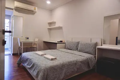 a bedroom with a bed with two towels on it at Sathon 15 apartment close to BTS Skytrain St Louis & Surasak in Bangkok