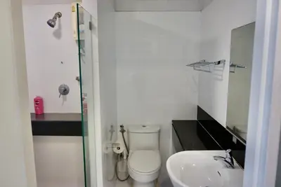 a white bathroom with a toilet and a sink at Hip & Funky Sathon15 apartment close to BTS St Louis in Bangkok