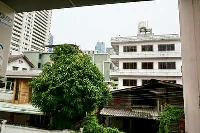 a tree in the middle of a city with buildings at Hip & Funky Sathon15 apartment close to BTS St Louis in Bangkok