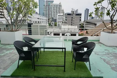 a glass table and chairs on top of a roof at Hip & Funky Sathon15 apartment close to BTS St Louis in Bangkok