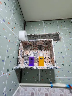 a shelf in a bathroom with different colored bottles at 113 Cozy Loft style with cool fan with free Wi-fi in Bangkok