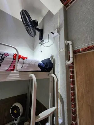 a small room with a bunk bed with a fan at 113 Cozy Loft style with cool fan with free Wi-fi in Bangkok