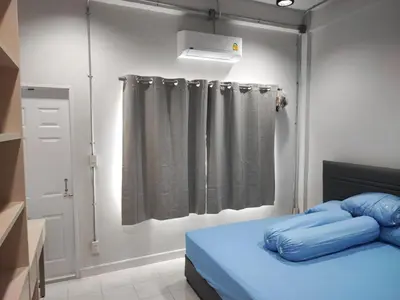 a bedroom with a bed and a shower curtain at Phenn's House @Ramkhamhaeng in Bang Kapi