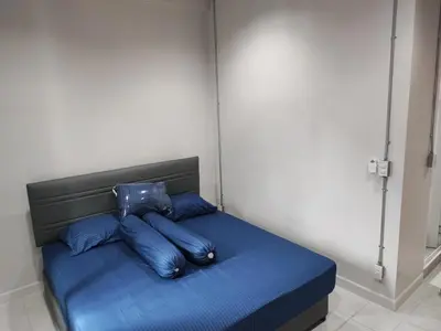 a bed with blue sheets and pillows in a room at Phenn's House @Ramkhamhaeng in Bang Kapi