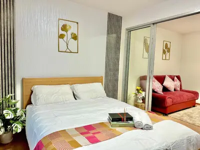 a bedroom with a bed and a red couch at เช่ารายเดือน DCon Rattanathibet in Ban Sai Ma