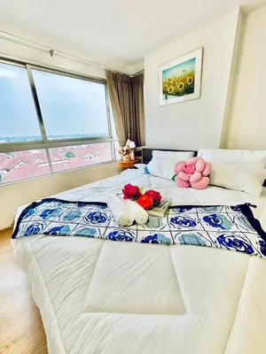 a bedroom with a large bed with flowers on it at เช่ารายเดือน DCon Rattanathibet in Ban Sai Ma
